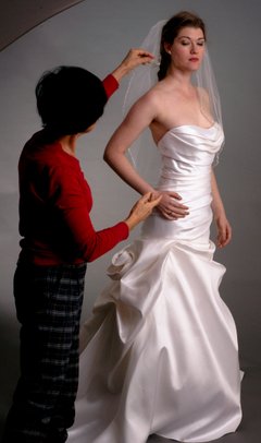 Svetlana adjusting a bridal gown on the model
